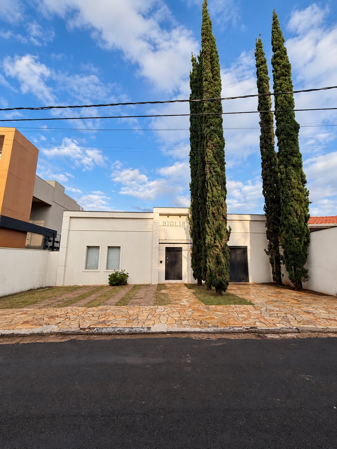 Fachada da sede da Petito Advocacia, com ciprestes junto à entrada